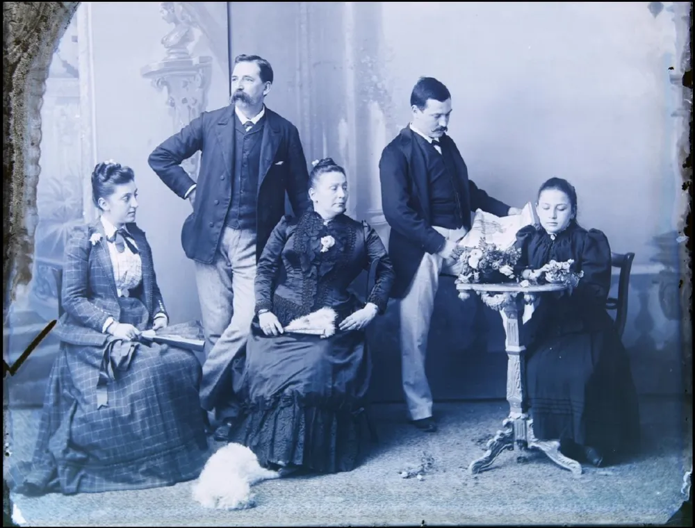 An 1880s studio portrait of a family, scanned with dust, scratches and a crease