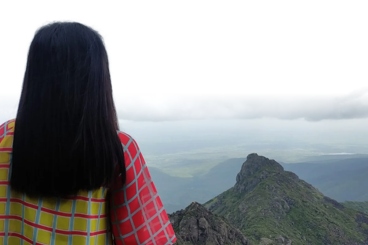 A woman looking out over mountains, with the sky replaced